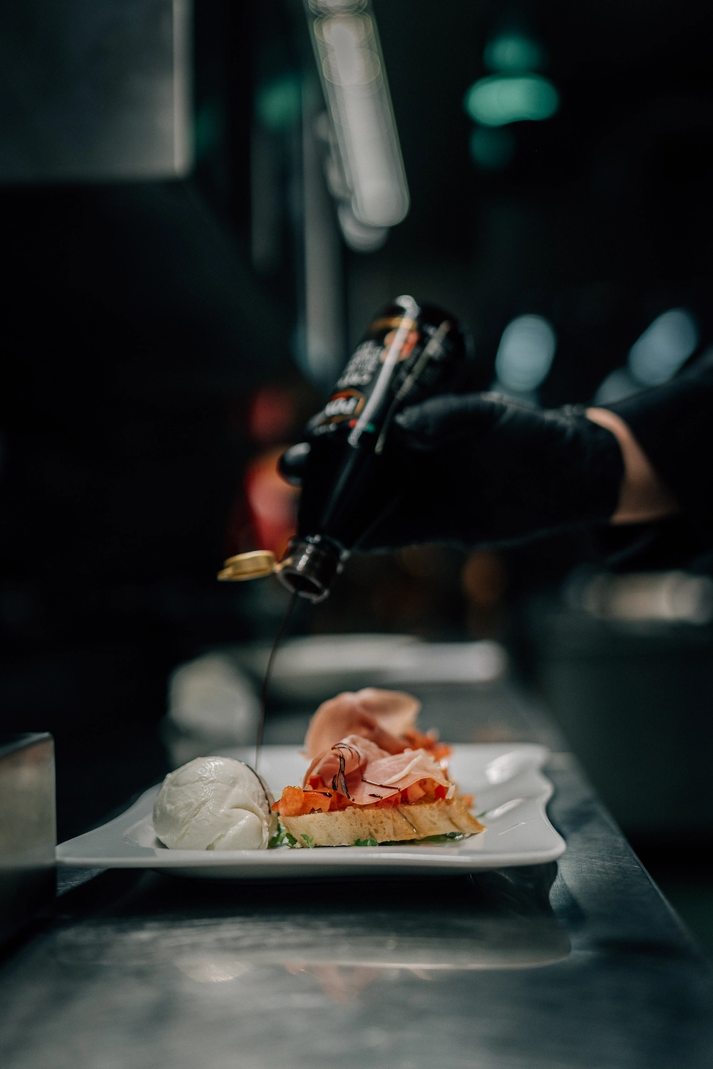 Sinn Kitchen – Restaurant – ein Koch bereitet Bruschetta mit Prosciutto und Mozzarella zu