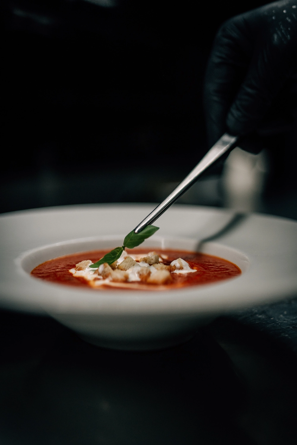 Sinn Kitchen - Restaurant - Ein Koch bereitet eine Schüssel Tomatensuppe zu.