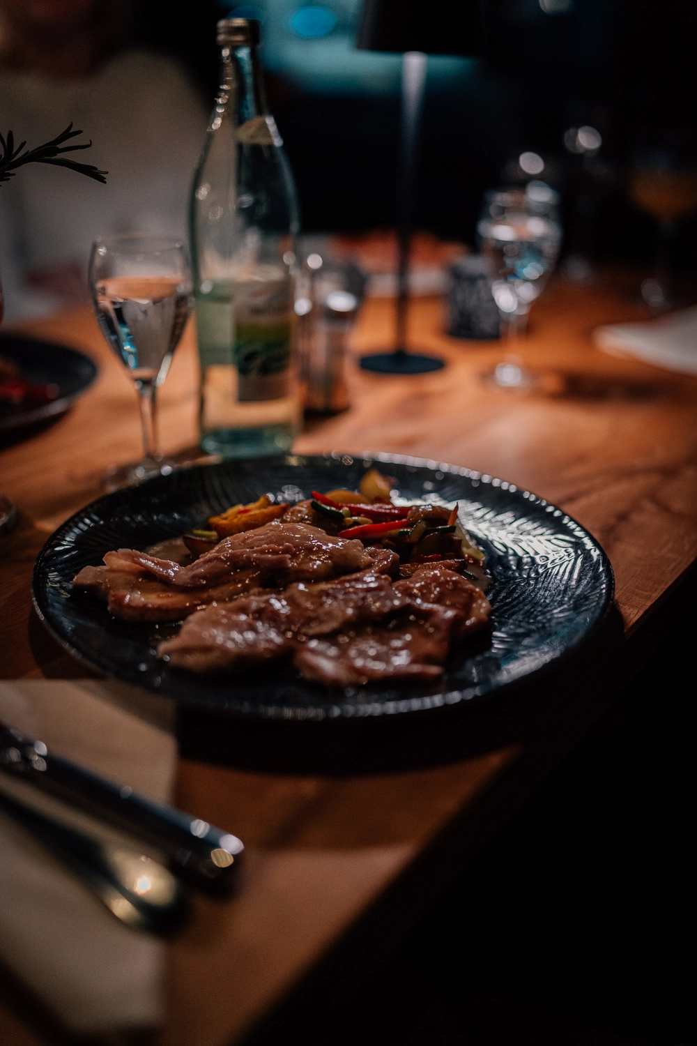 Sinn Kitchen – Restaurant – eine Mahlzeit, die in einem schwach beleuchteten Restaurant oder Essbereich serviert wird.